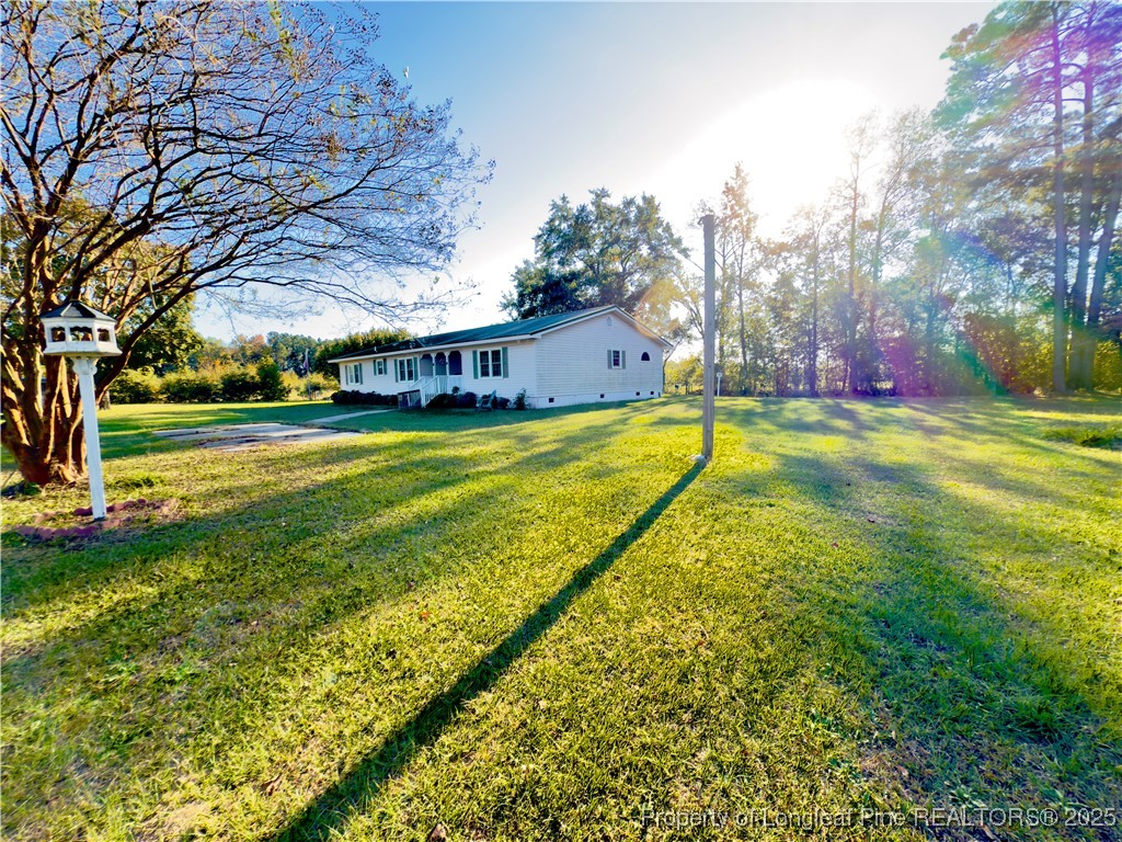4506 Tobacco Road Orrum, NC 28369 - Photo 42 of 46 a view of a house with a big yard and palm trees