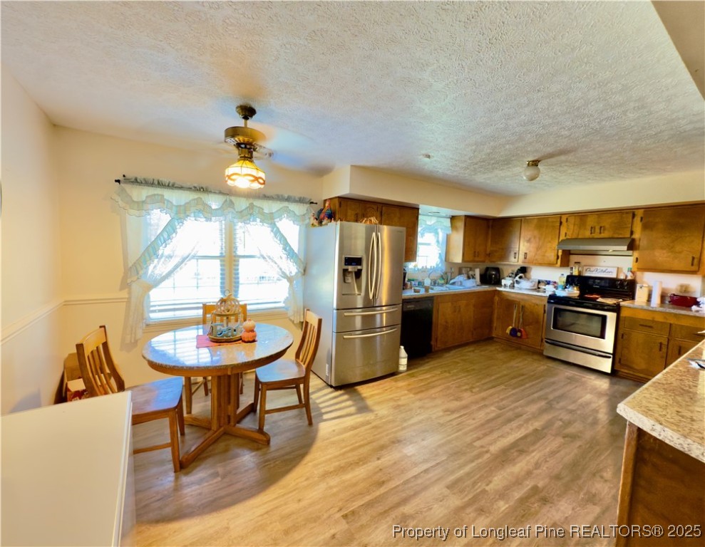 4506 Tobacco Road Orrum, NC 28369 - Photo 5 of 46 a kitchen with stainless steel appliances kitchen island granite countertop a sink cabinets and wooden floor