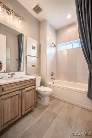 a bathroom with a granite countertop sink toilet a large mirror a bathtub and next to a window