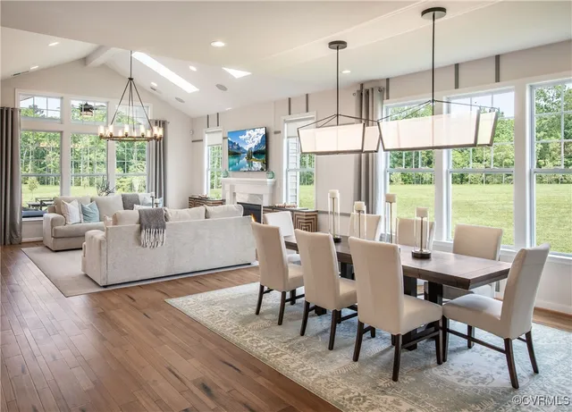 a living room with furniture a large window and dining table
