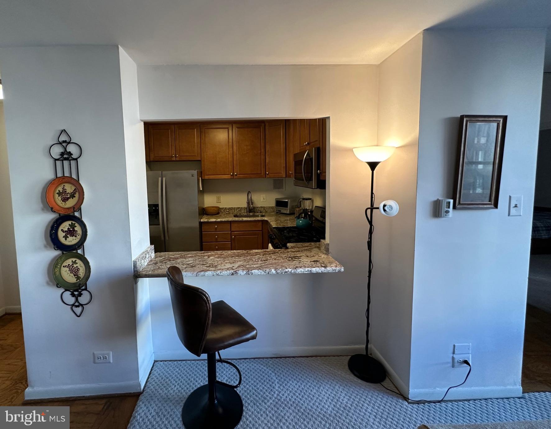a kitchen with stainless steel appliances granite countertop a refrigerator and a stove