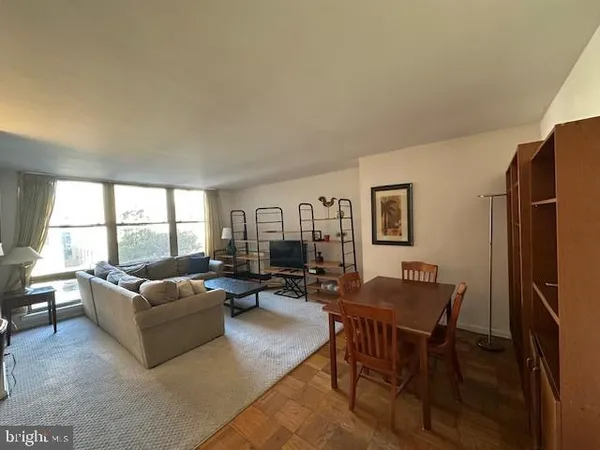 a living room with furniture wooden floor and a large window