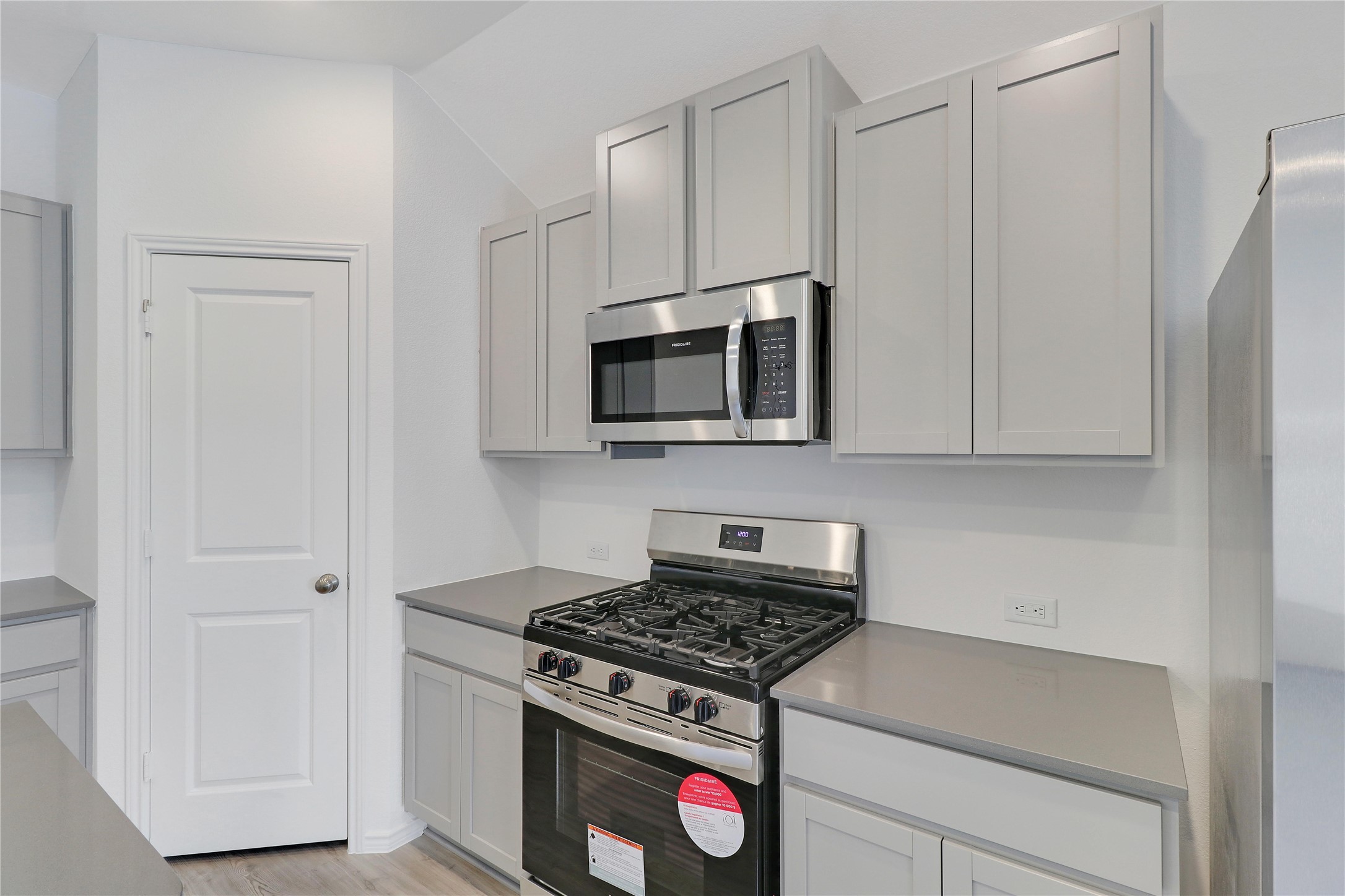 2524 Four Waters Loop Georgetown, TX 78628 - Photo 9 of 36 a kitchen with stainless steel appliances a stove a microwave and cabinets