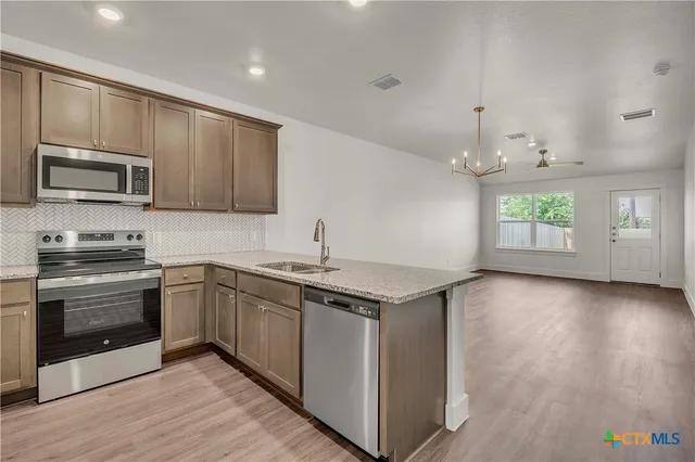 wooden floor in an empty room with a kitchen