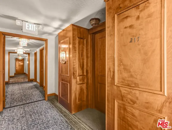 an empty room with wooden floor and a kitchen