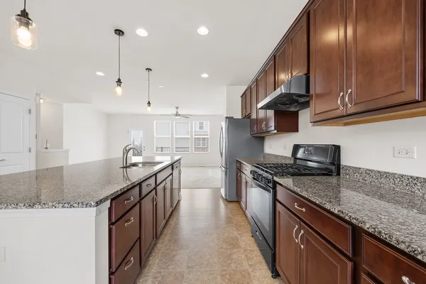 a kitchen with stainless steel appliances granite countertop a sink a stove and a refrigerator