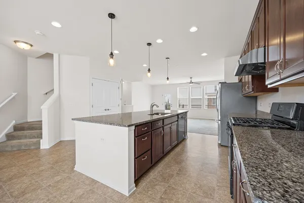 a large kitchen with stainless steel appliances granite countertop a stove a sink and a refrigerator