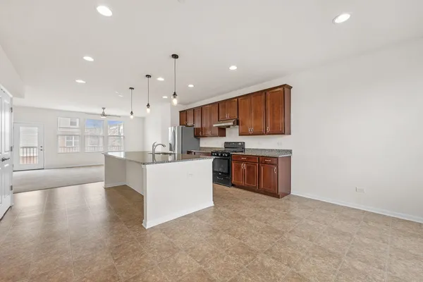 a large kitchen with stainless steel appliances granite countertop a large counter top and a stove top oven