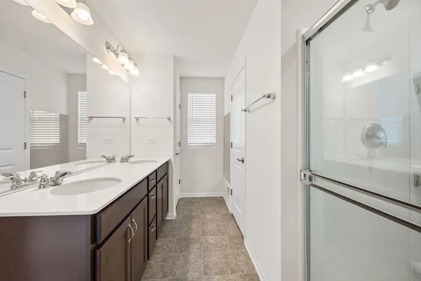 a bathroom with a double vanity sink a mirror and a shower