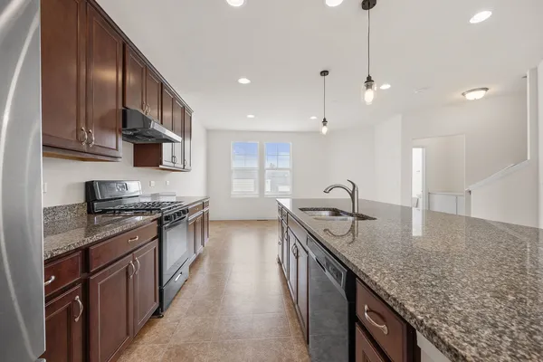 a kitchen with stainless steel appliances granite countertop a sink stove and refrigerator