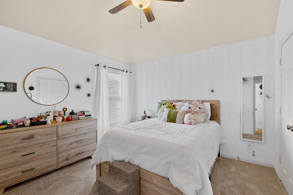4004 White Porch Road Plano, TX 75024 - Photo 26 of 40 a bedroom with a bed a mirror on dresser and a chandelier