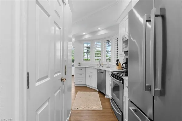 a kitchen with white cabinets and stainless steel appliances