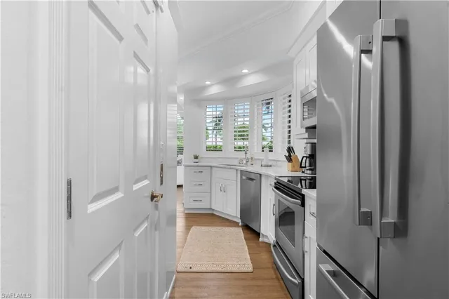 a kitchen with white cabinets and stainless steel appliances