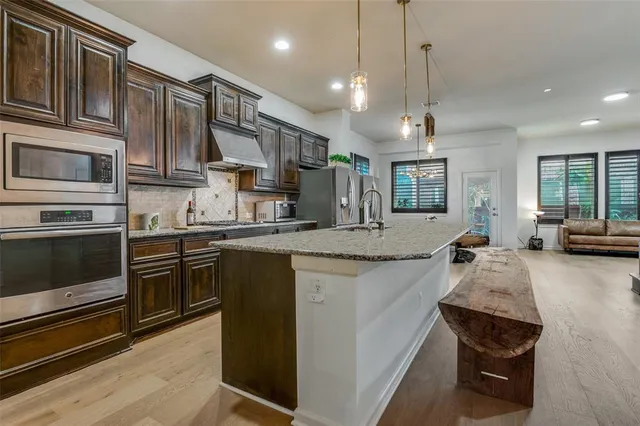 a kitchen with stainless steel appliances granite countertop a stove and cabinets