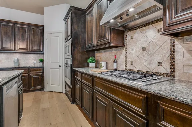a kitchen with stainless steel appliances granite countertop a stove and a refrigerator