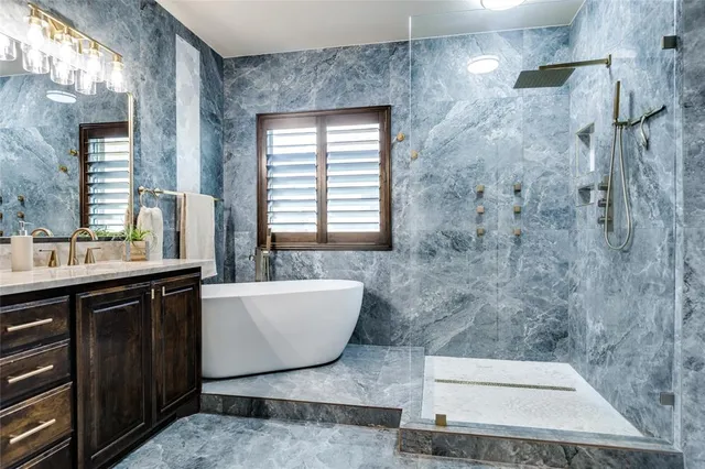 a bathroom with a sink a bathtub a mirror a vanity and a shower