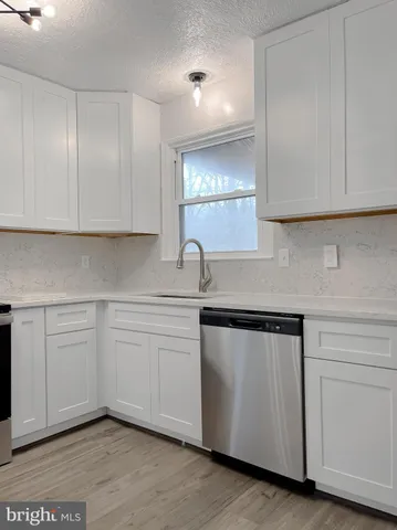 a kitchen with white cabinets appliances and a sink