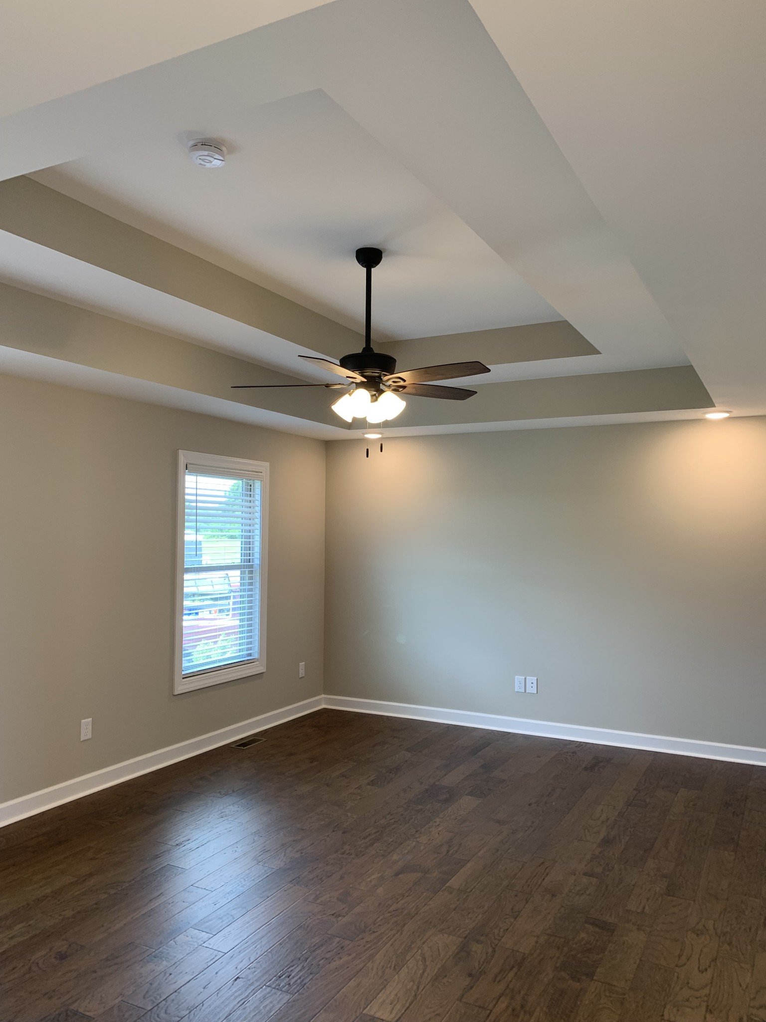 589 Womack Road Bethpage, TN 37022 - Photo 12 of 20 an empty room with wooden floor chandelier fan and windows