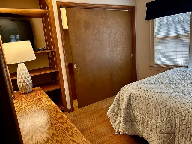 a bed sitting in a bedroom next to a window