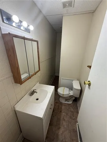 a bathroom with a sink a toilet and mirror