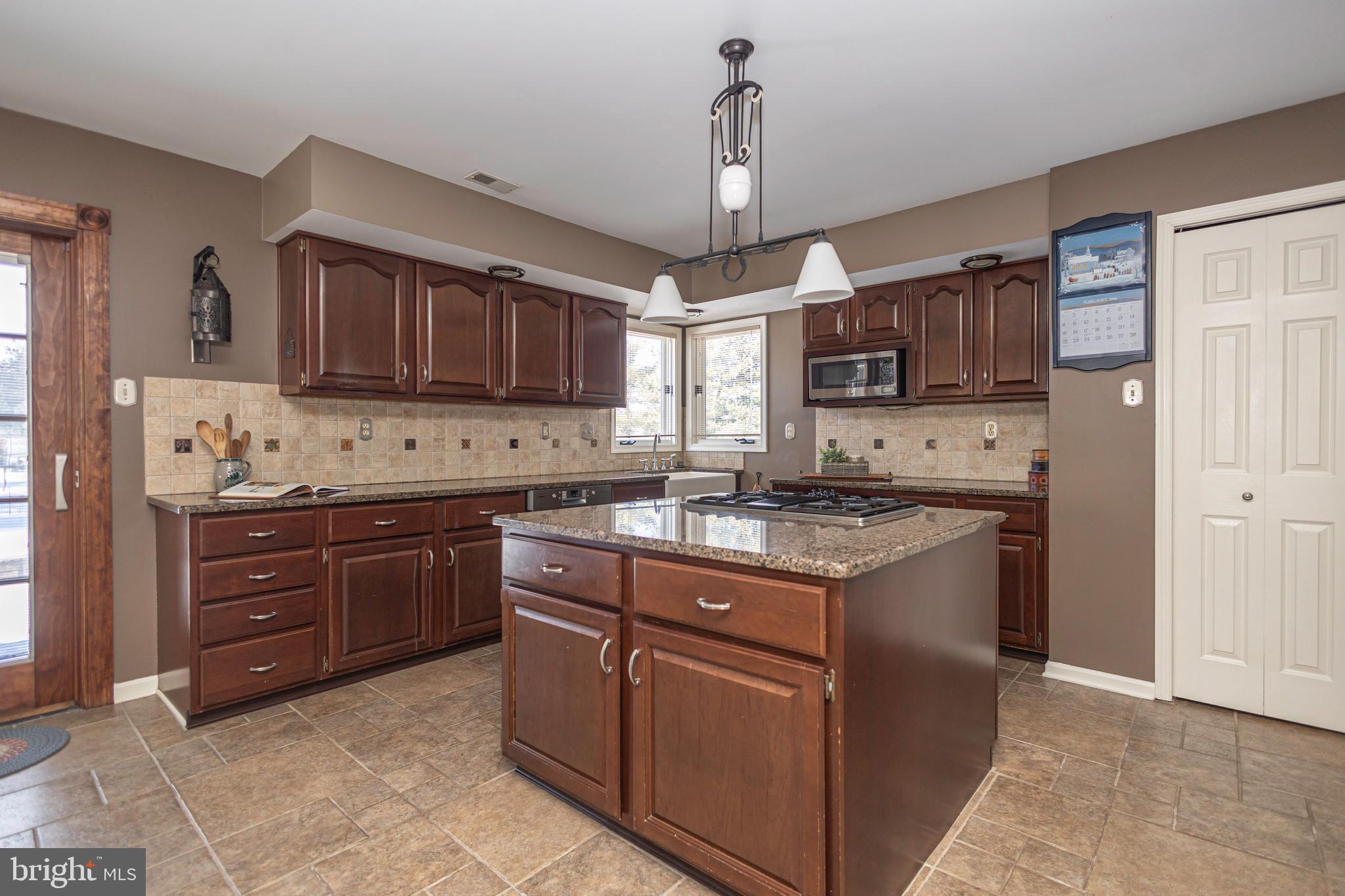 895 Slate Hill Road Yardley, PA 19067 - Photo 23 of 67 a kitchen with stainless steel appliances granite countertop a stove a sink dishwasher a refrigerator and a microwave oven