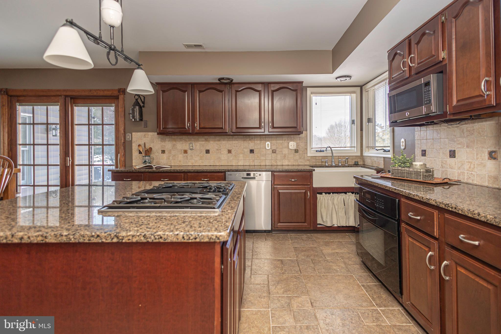 895 Slate Hill Road Yardley, PA 19067 - Photo 26 of 67 a kitchen with kitchen island granite countertop a sink a counter top space appliances and cabinets