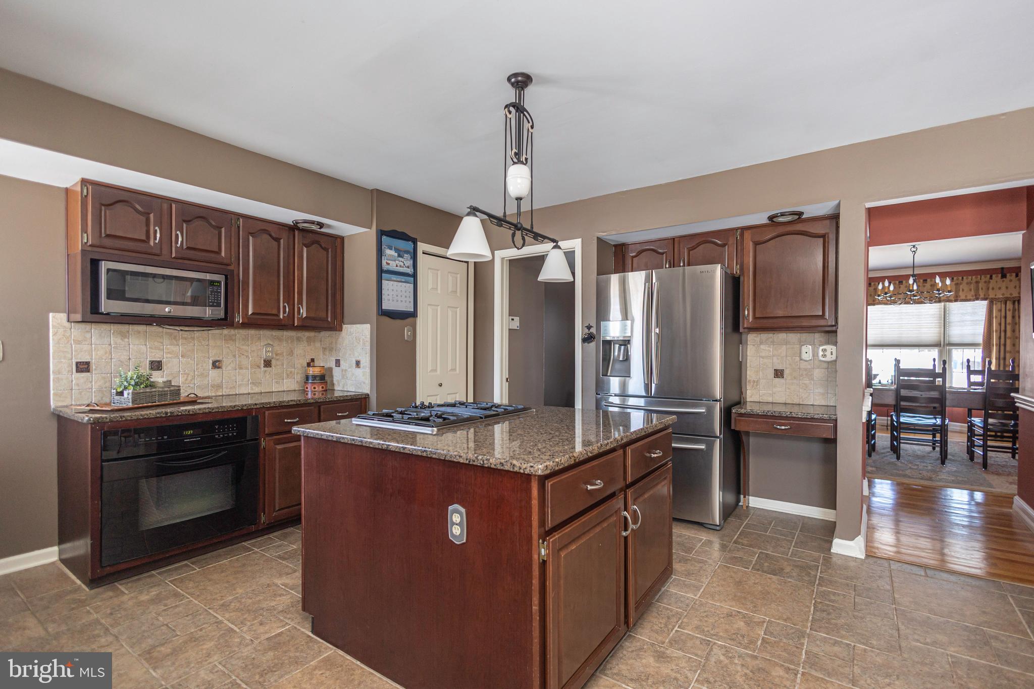 895 Slate Hill Road Yardley, PA 19067 - Photo 28 of 67 a kitchen with stainless steel appliances granite countertop a stove refrigerator and microwave