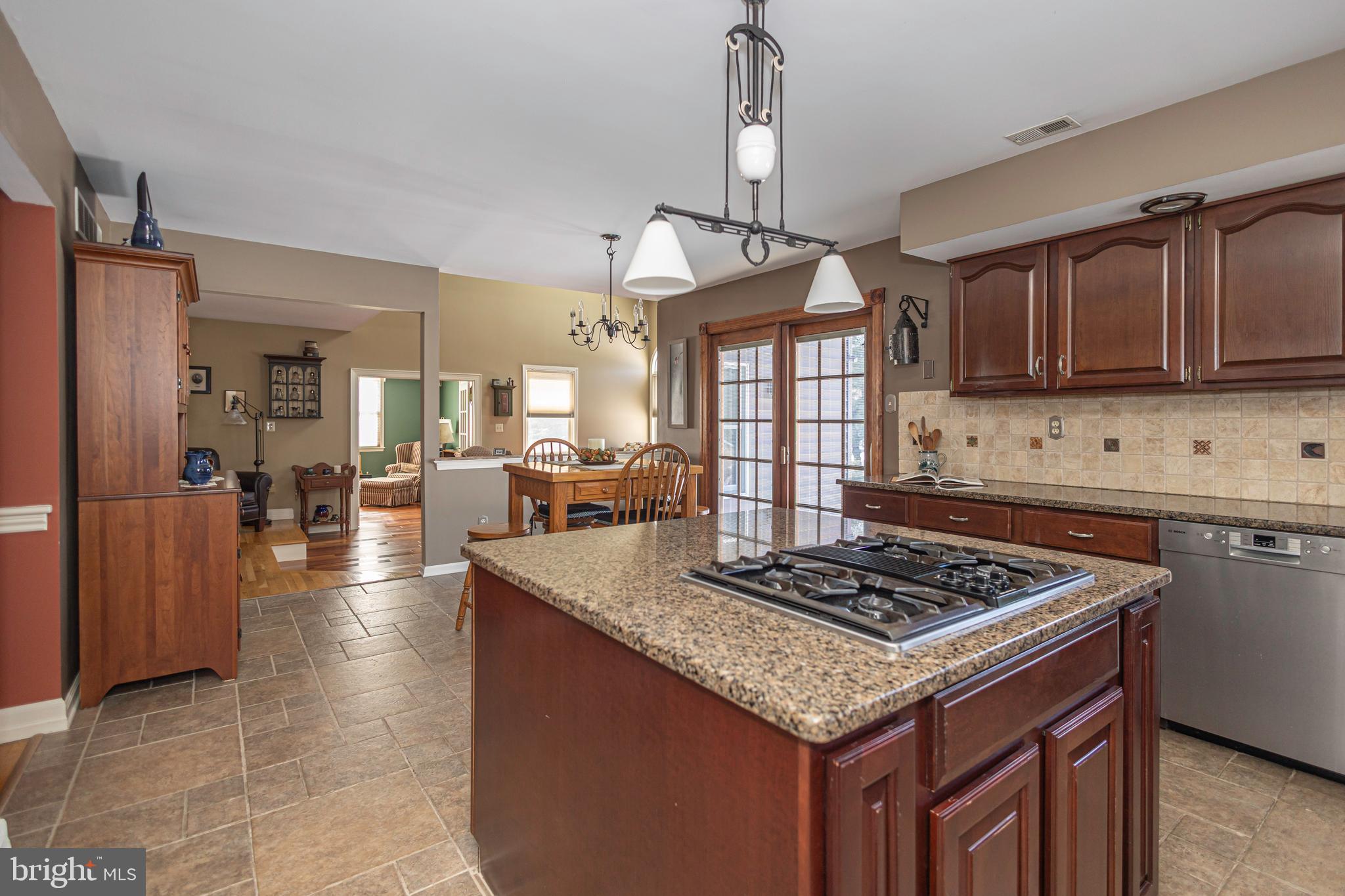 895 Slate Hill Road Yardley, PA 19067 - Photo 29 of 67 a kitchen with granite countertop a stove a refrigerator a sink dishwasher with a dining table and chairs