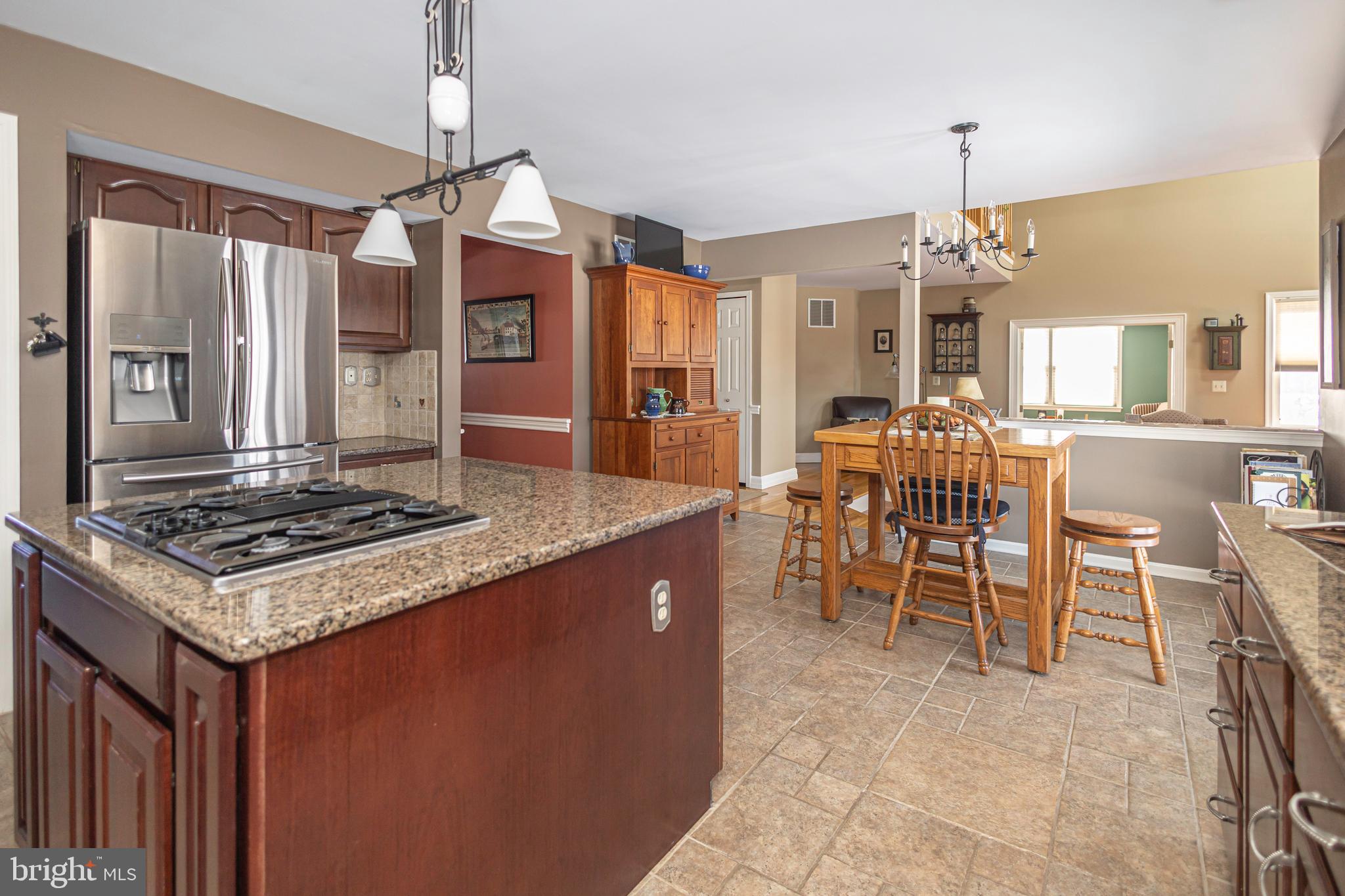 895 Slate Hill Road Yardley, PA 19067 - Photo 31 of 67 a kitchen with stainless steel appliances granite countertop a stove top oven a sink a dining table and chairs