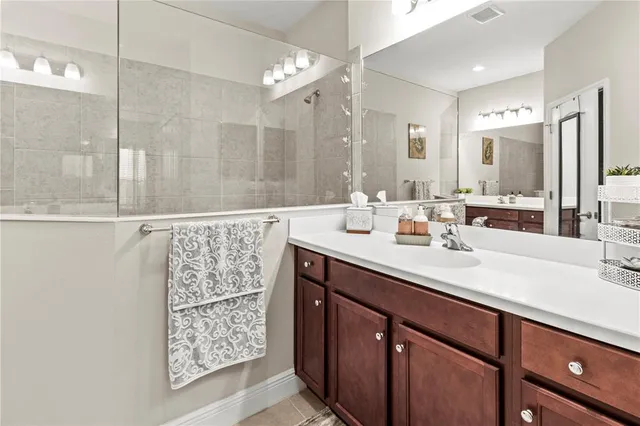 a spacious bathroom with a double vanity sink a large mirror a shower and a bathtub