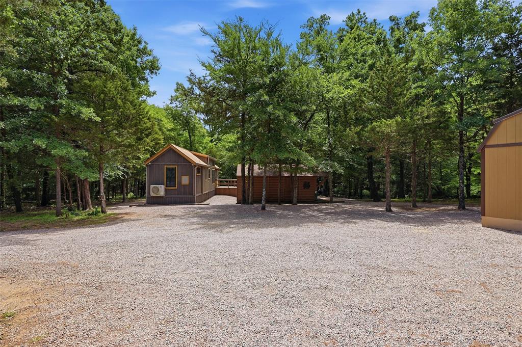3958 Ranch Road Whitesboro, TX 76273 - Photo 30 of 40 Gravel driveway with multiple structures surrounded by mature trees