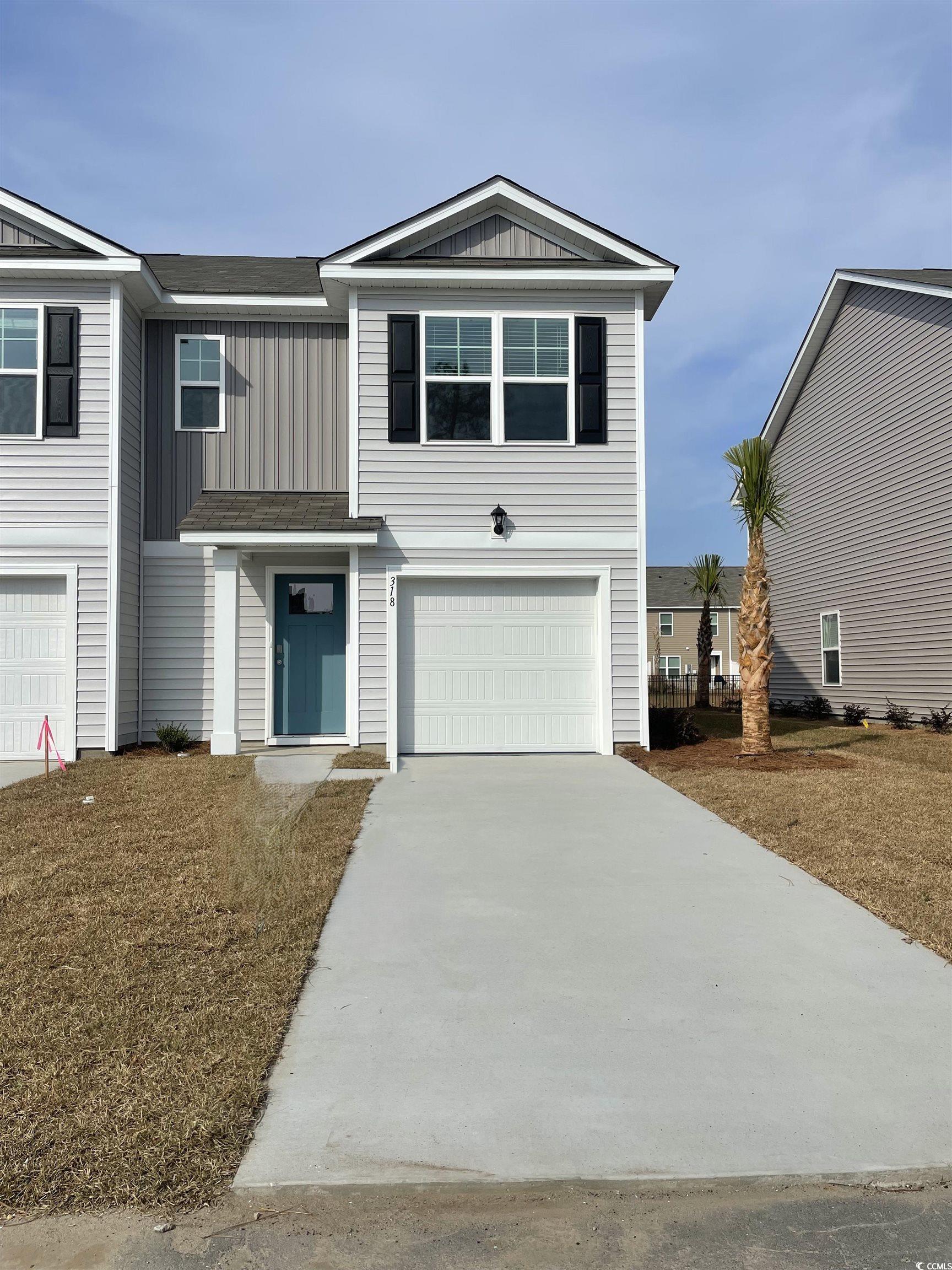 318 Bayou Loop, Unit LOT 65 Surfside Beach, SC 29575 - Photo 1 of 17 View of front facade with driveway, board and batten siding, and a garage