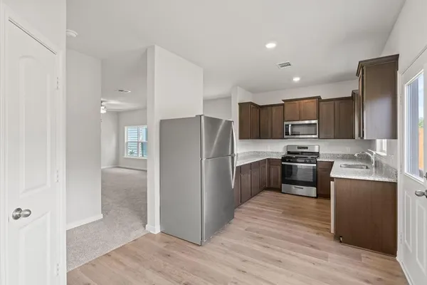 a kitchen with granite countertop stainless steel appliances and wooden cabinets