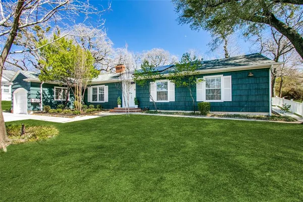 a view of a house with backyard and a tree