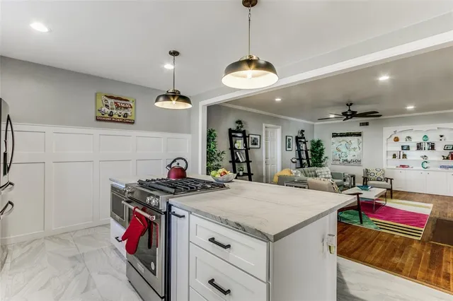 a view of a dining room and livingroom with furniture wooden floor a chandelier