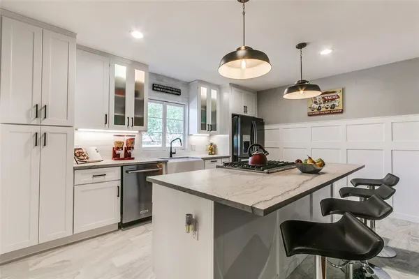 a kitchen that has a stove a table and chairs in it
