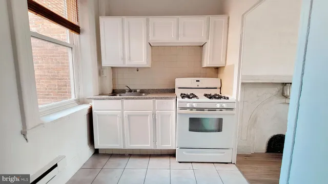 a kitchen with cabinets appliances and a window
