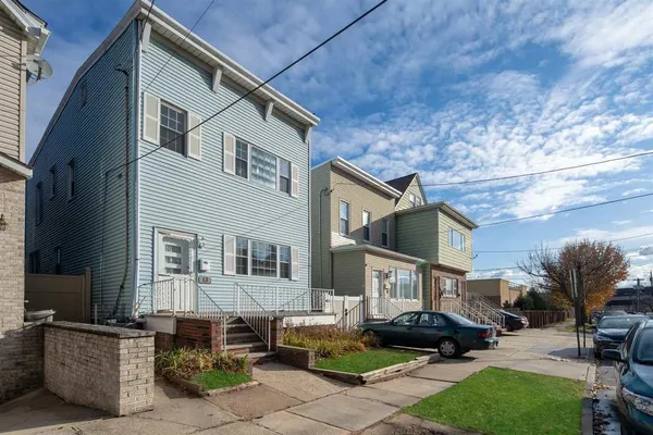 a front view of a house with cars parked