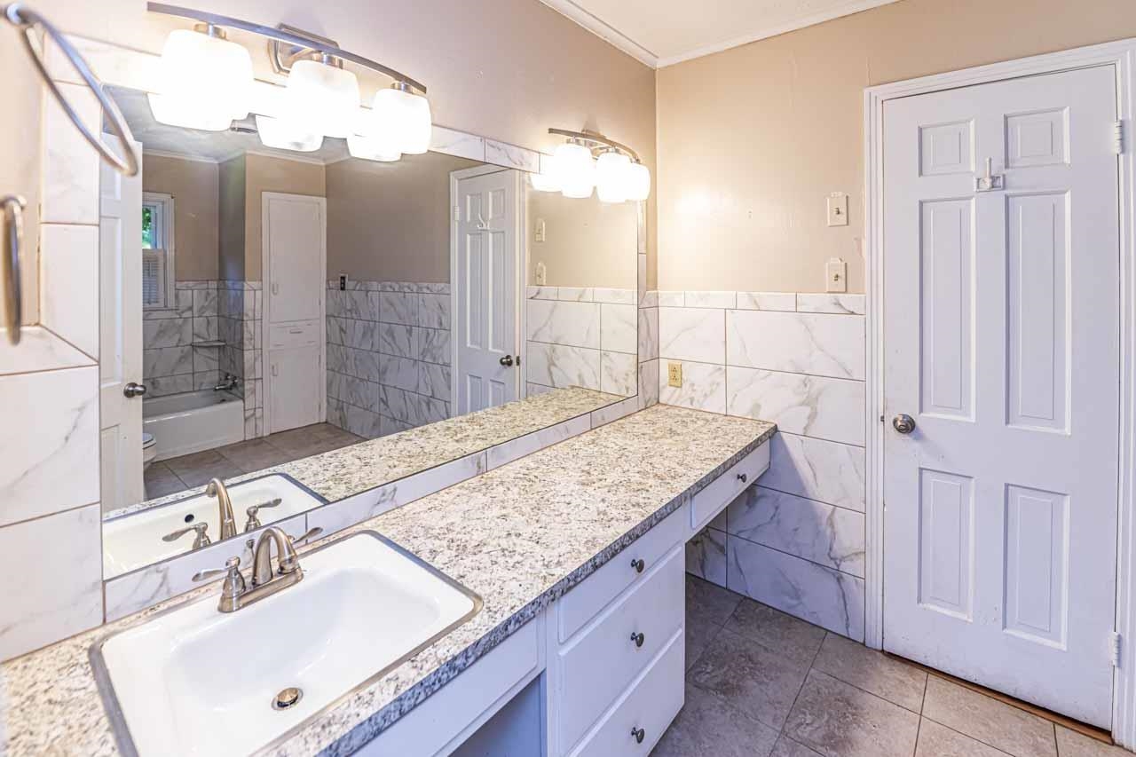 725 Old Brownsville Road Ripley, TN 38063 - Photo 16 of 40 a bathroom with a sink vanity granite tub shower and a mirror