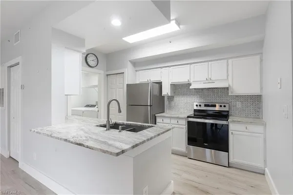 a kitchen with stainless steel appliances granite countertop a sink stove and refrigerator
