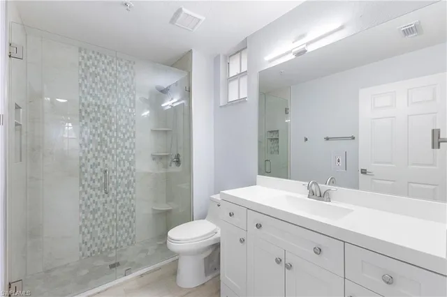a bathroom with a sink a toilet a shower and a mirror