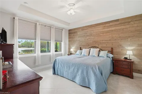 a bedroom with a bed a large window and flat screen tv