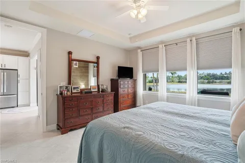 a bedroom with a large bed and a flat tv screen on dresser