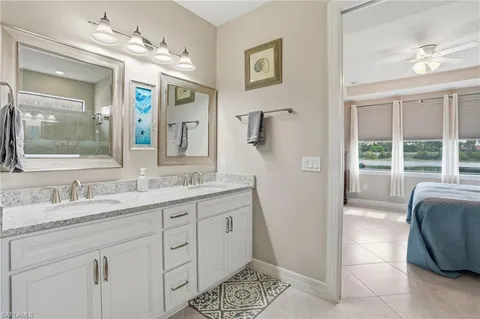 a en suite bathroom with a granite countertop sink a mirror and a shower