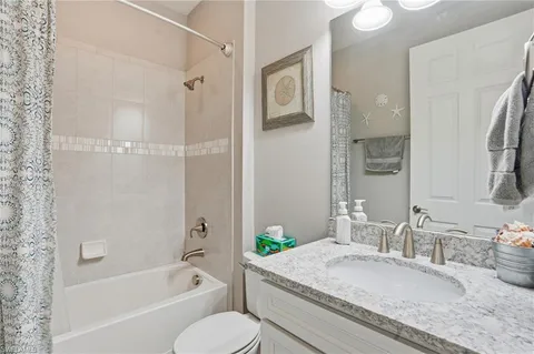 a bathroom with a granite countertop tub sink toilet and shower