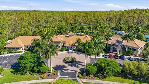 an aerial view of residential houses with outdoor space and trees