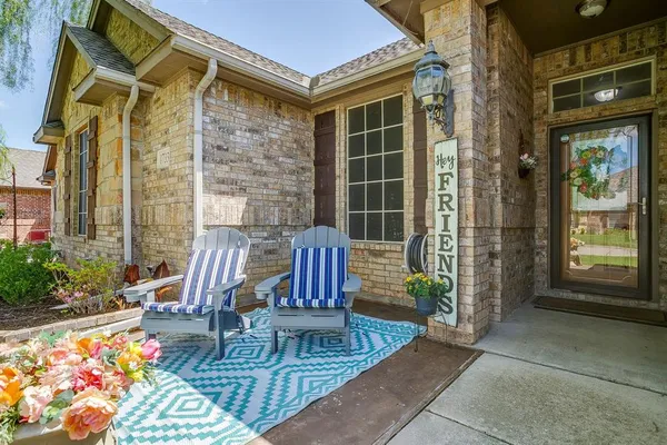 a view of a patio with couple of chairs and a potted plant