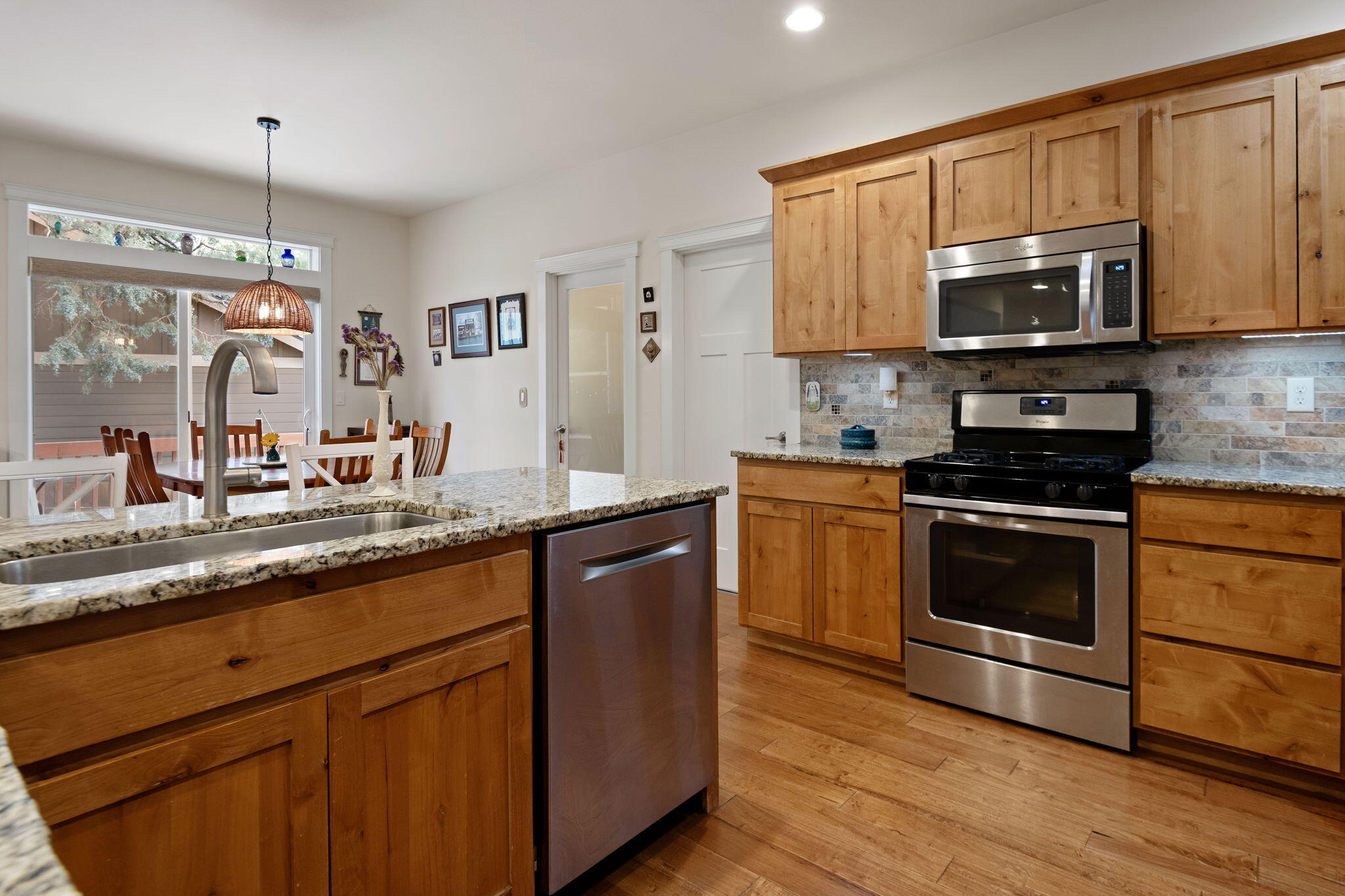 62944 Fresca Street Bend, OR 97703 - Photo 6 of 32 a kitchen with granite countertop wooden cabinets stainless steel appliances and a counter space