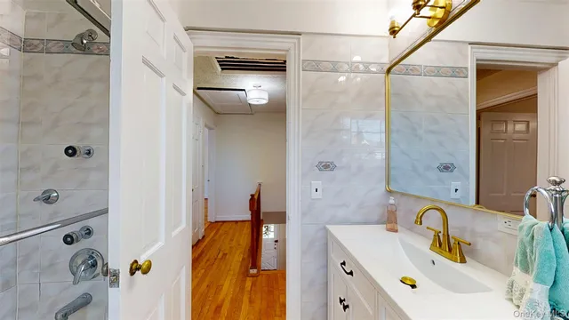 a bathroom with a tub sink and mirror