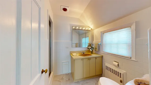 a bathroom with a sink a toilet a mirror and shower